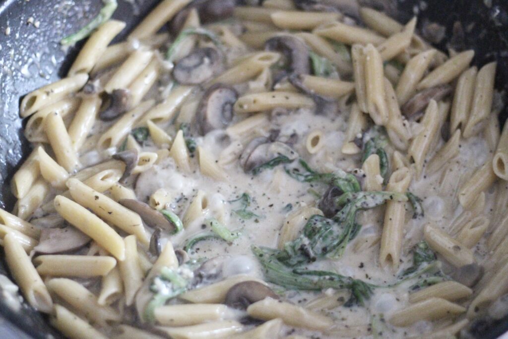 Creamy mushroom pasta cooking on stovetop