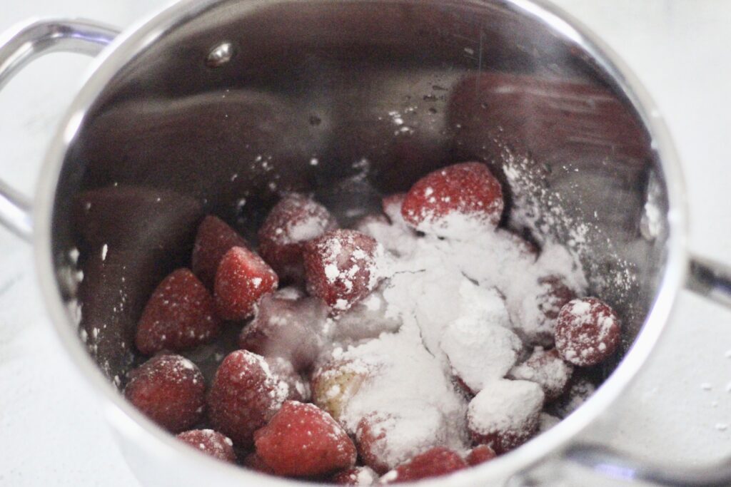 Strawberry preserve ingredients in a saucepan on the stove