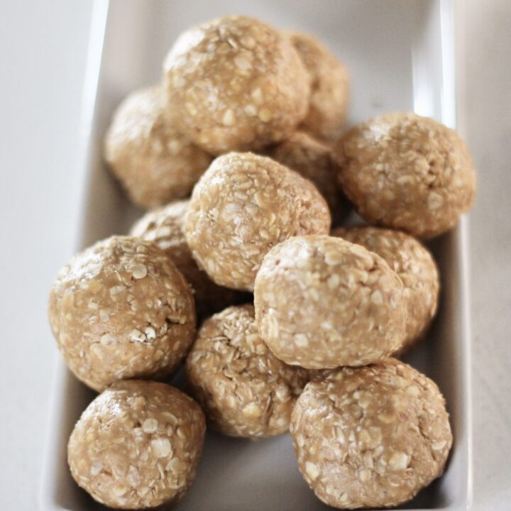 Oatmeal peanut butter balls stacked on each other on white dish