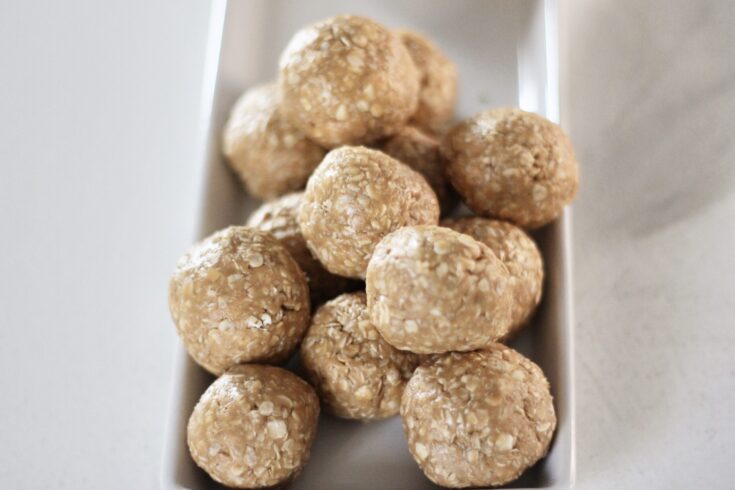 Oatmeal peanut butter balls stacked on each other on white dish