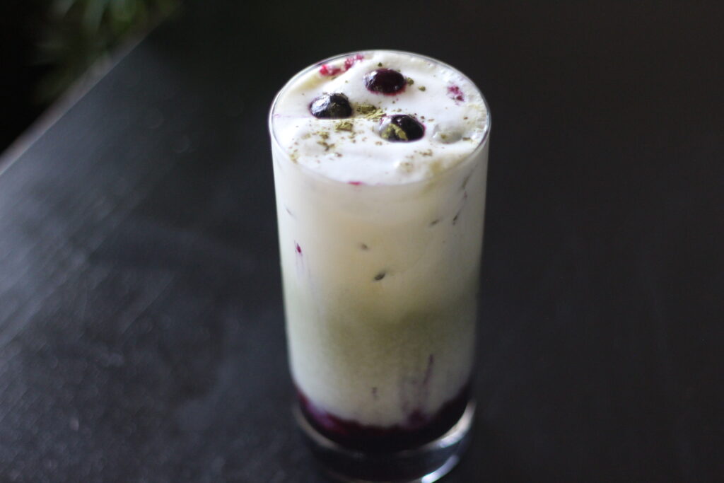 Blueberry Matcha latte on table with blueberries on top