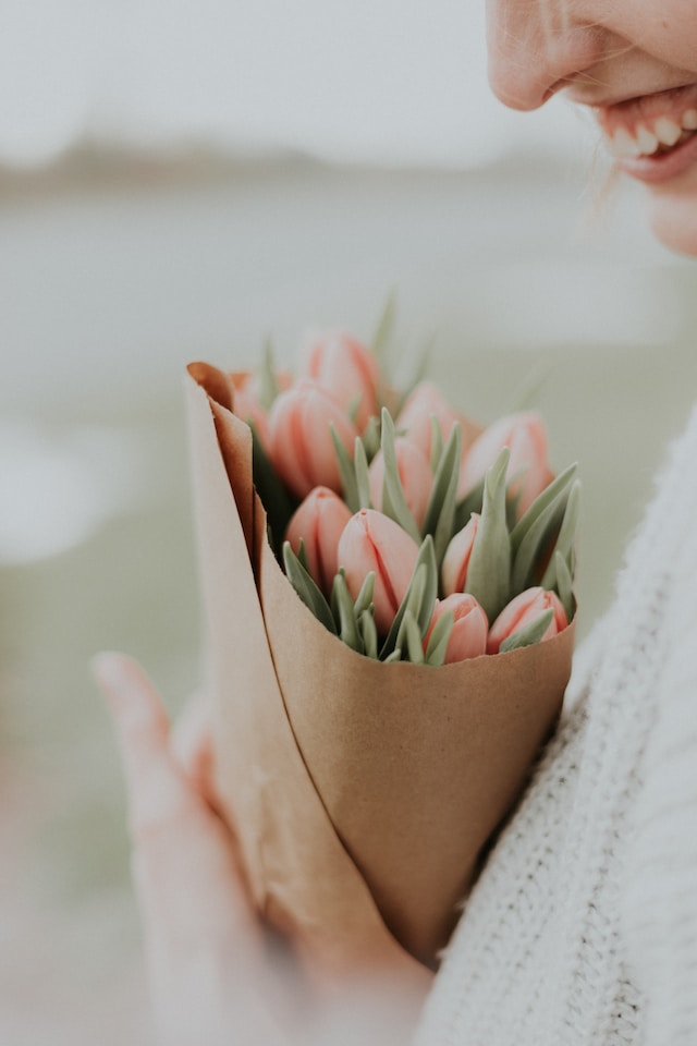 A bouquet of tulips wrapped in brown paper