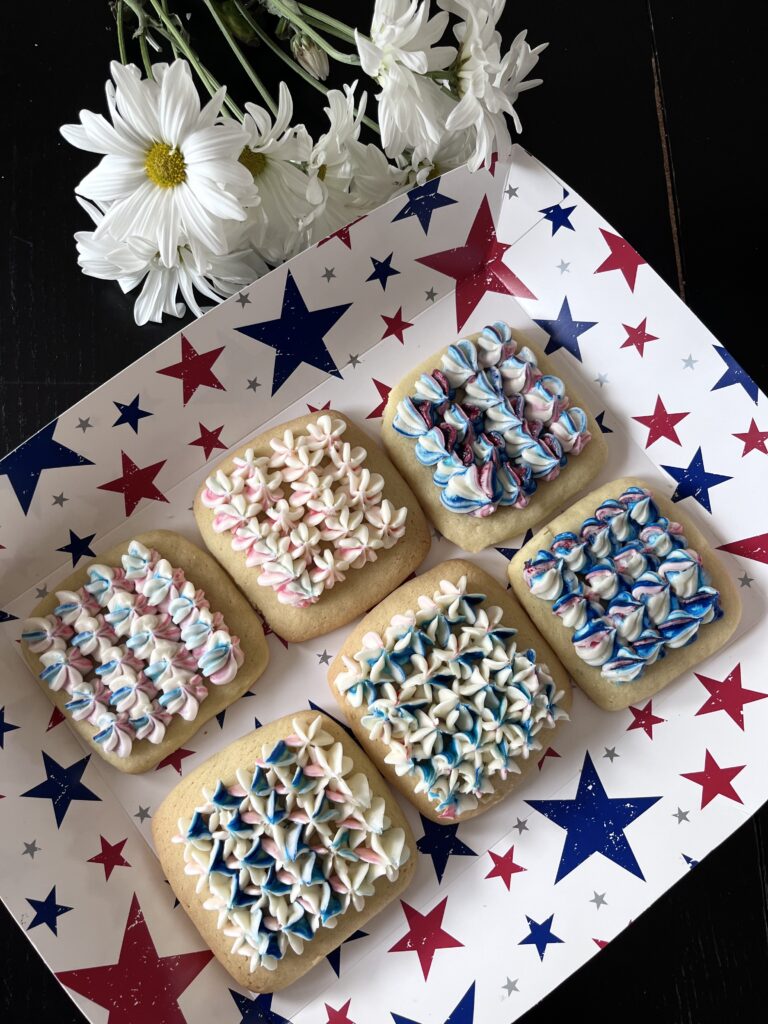 Red, white and blue frosted sugar cookies on patriotic plate