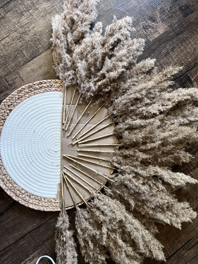 Pompas grass stems glued to cardboard on a placemat